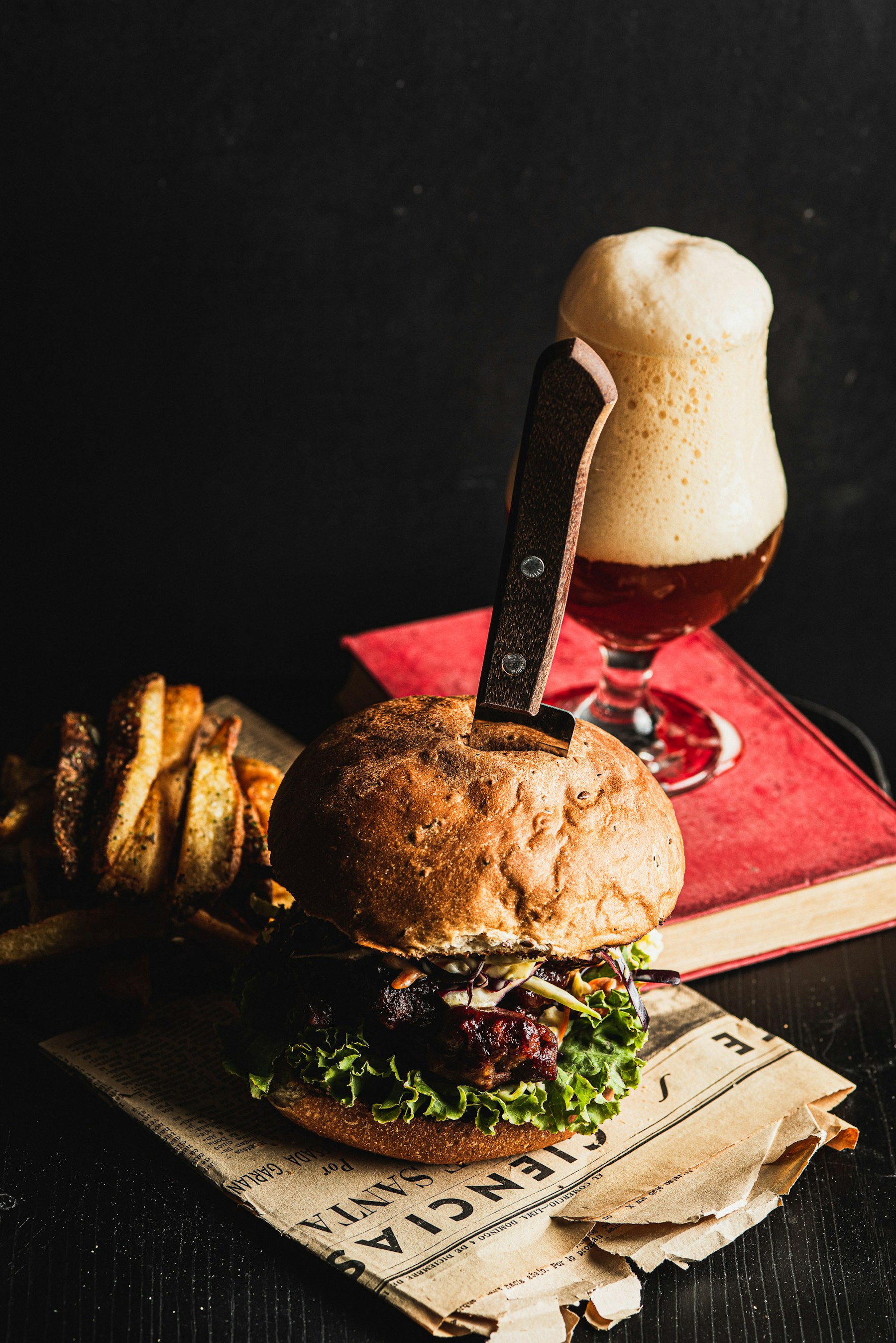 Editorial food photography of a burger, fries and a beer; illustrative, not a photo of EAT's exact dishes